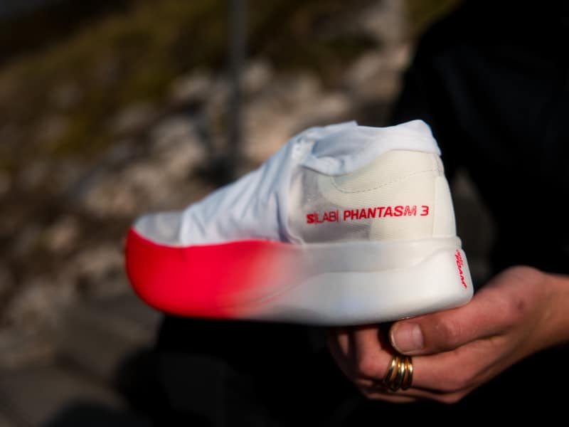 La sortie de la nouvelle chaussure carbone n’est pas passée inaperçue. Après un lancement du côté de Paris et une campagne axée autour d’images en soufflerie dignes des plus grandes équipes de cyclisme, la nouvelle Salomon S/LAB Phantasm 3 donne un nouvel élan à la marque alpine dans l’univers du road running. Si Salomon a su s’imposer comme l’un des leaders dans l’outdoor, il leur fallait encore améliorer leur produit sur la route. Avec cette troisième version de la Phantasm, Salomon se repositionne aux côtés des meilleurs modèles de chaussures à plaque carbone du marché. Nous avons pris le temps de tester la Salomon S/LAB Phantasm 3 sur plusieurs séances, et voici nos retours.