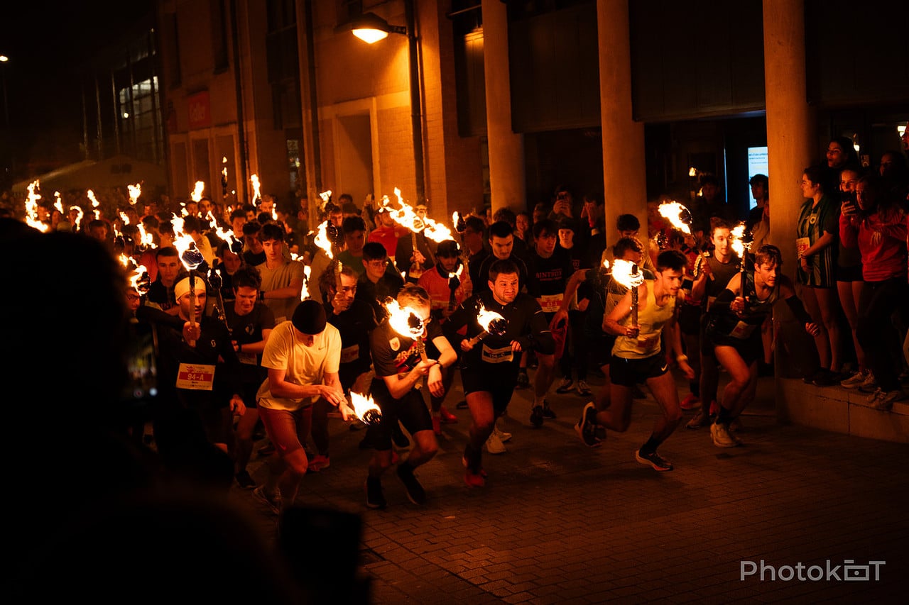 Les étudiants illuminent Louvain-la-Neuve lors de la Course aux flambeaux, une soirée sportive et conviviale.