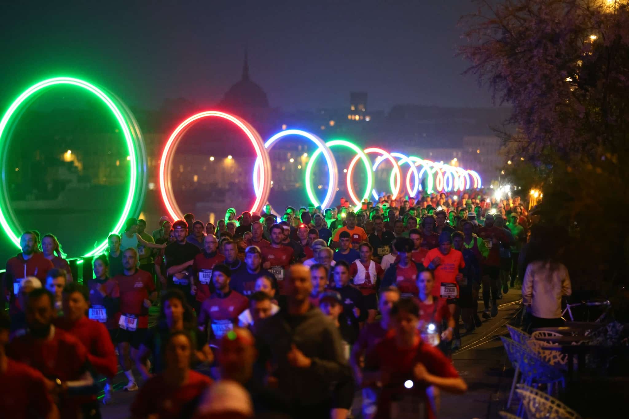 Des grands rendez-vous à l'instar des Foulées de l’éléphant aux Glow Runs façon dancefloor, en passant par des courses et ekiden plus discrets en pleine nature, les courses à pied nocturnes gagnent du terrain. Moins codifiées, plus libres dans leur format et souvent empreintes d’une ambiance festive, elles séduisent un public toujours plus large, en quête d’une autre manière de courir : un peu plus loin du chrono, un peu plus proche des sensations. Tour d’horizon d’un phénomène qui ne ronfle jamais.